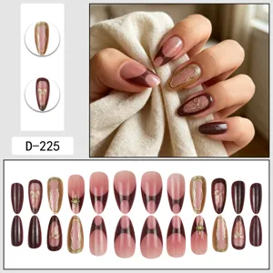 Close-up details of short almond press-on nails featuring 3D gold foil lines and cute bows.