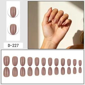 Nude press-on nails detail view showcasing the smooth glossy finish and delicate rhinestone accent.