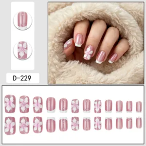 Detailed view of 3d flower press-on nails with french tips and water drop gel effect.