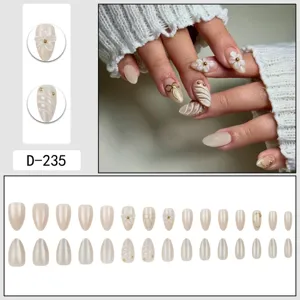 Nude press-on nails set with 3D floral, gold bow and wave texture design for elegant look.