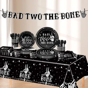 Detailed showcase of skeleton hand party tableware set including themed plates, cups and banner.