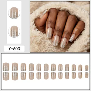 Press-on false nails featuring a chic nude base with sparkling silver glitter gradient tips.