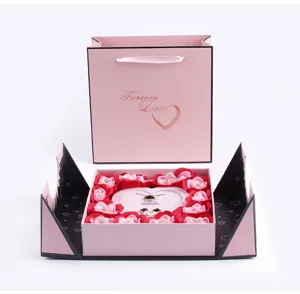 Coffret cadeau rose Saint-Valentin détail ensemble bijoux, sac en papier rose et pétales de fleurs.