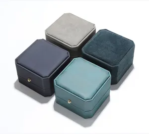 Detalle de primer plano de joyeros octagonales de terciopelo PU para anillos y pendientes variados.