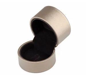 Detail view of cylindrical brushed leather jewelry box with soft black velvet interior slot.
