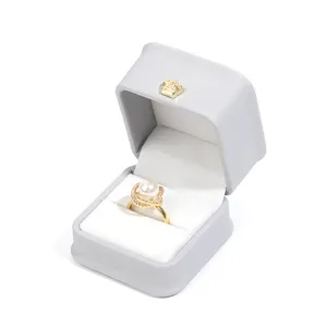 Grey PU leather ring box with white velvet lining and gold crown decoration for jewelry.
