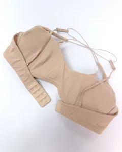 Detail view of a nude wireless bra with thin cross straps and back closure for women.