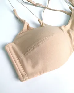 Detailed close-up of a seamless wireless thin nude bra featuring stylish cross straps and soft fabric.
