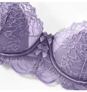 Gros plan sur les détails en dentelle violette du soutien-gorge avec des motifs et des nœuds.