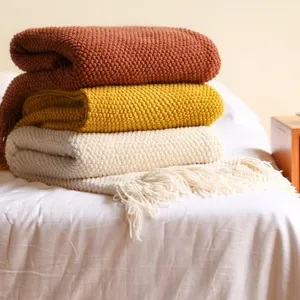 Soft pineapple grid knit blanket detail showing cozy texture and elegant fringe design.