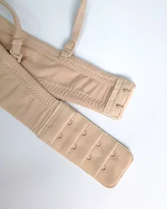 Close-up detail of nude color bra back strap, multi-row hook and eye closure, soft fabric.