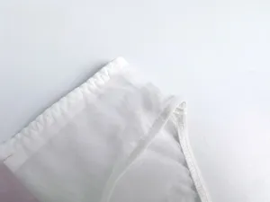 Detalle de tela de lencería de malla blanca transparente con costuras finas y textura suave.