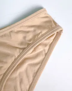 Details van damesondergoedstof, zachte huidskleur, schone stiksels en nette randen.