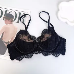 Detalle de sujetador de encaje negro con delicado patrón floral y borde festoneado elegante.
