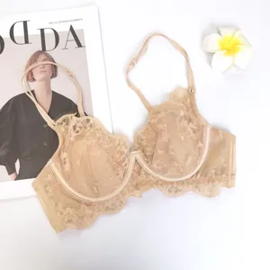 Vista detallada del sujetador de encaje beige para mujer con delicado patrón floral y tirantes.