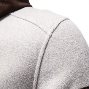 Close-up detail of mens fleece hoodie, contrast suede patchwork, thick warm winter outerwear.