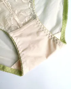 Detailaufnahme von Damen-Spitzenunterwäsche mit weichem Mesh und elegantem grünem Saum.