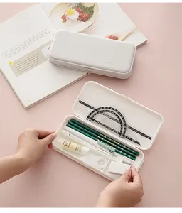 Minimalist frosted plastic pencil box detail view, showing partitioned interior and student stationery.