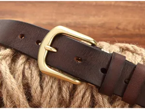 Dettaglio cintura in vera pelle da uomo con fibbia ad ardiglione in ottone vintage.