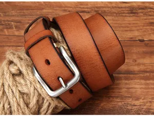 Detail van een bruine rundleer riem met klassieke metalen gesp en vintage textuur voor heren.