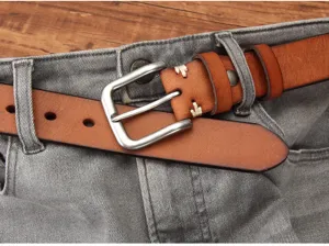 Close-up van een stijlvolle bruine heren leren riem met zilveren gesp op een grijze jeans.