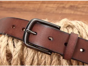 Close-up detail of retro brown cowhide leather belt with dark metal buckle and rustic hemp.