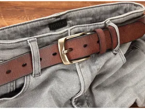 Close-up of genuine leather belt with metal pin buckle and grey denim jeans detail shot.