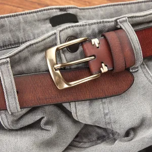 Men's vintage genuine leather belt with classic metal pin buckle and stylish casual denim jeans.