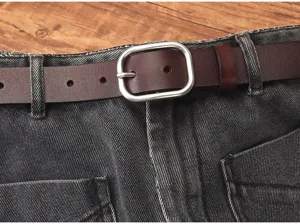 Primer plano detalle de cinturón de mujer de cuero genuino vintage con hebilla en vaqueros.