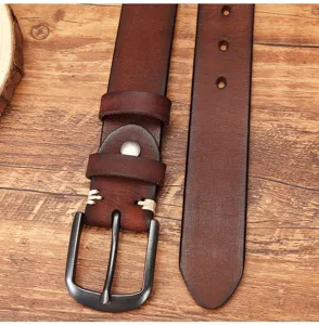 Close-up detail of men's genuine leather retro belt, vintage cowhide with solid metal buckle.