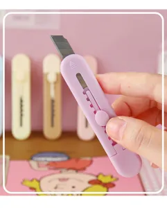 Detailopname van een pastelkleurig mini hobbymes met intrekbaar mes voor op kantoor.