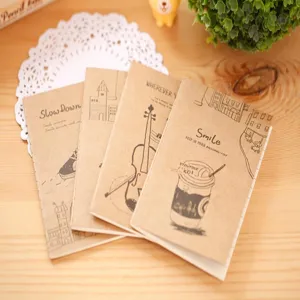Vue détaillée de carnets en papier kraft rétro avec des illustrations vintage sur bureau bois.
