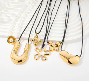 Primer plano detallado de elegantes collares con colgante bañado en oro minimalista.