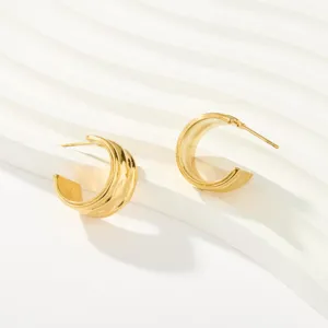 Primer plano de pendientes de aro geométricos chapados en oro de 18k sobre fondo blanco.