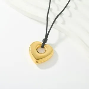 Detalle de collar con colgante de corazón dorado, brillo metálico elegante y estilo chic.