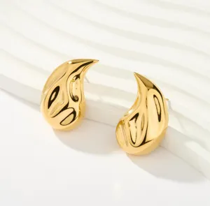 Vergoldete abstrakte tropfenförmige gedrehte Ohrringe Detailansicht, minimalistischer Schmuck.