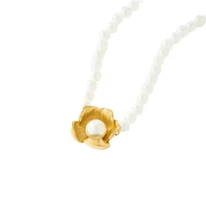 Detalle de joyería de collar de perlas de imitación con colgante de flor dorada