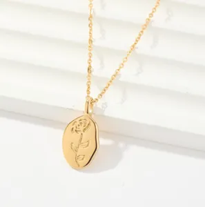 Detailed shot of gold-colored necklace featuring an elegant engraved rose oval pendant.