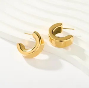 Klobige goldene Creolen, dickes C-Form-Design, hochwertige minimalistische Schmuckdetailansicht.