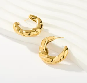 Goldene verdrehte Creolen für Damen, schicker, klobiger Statement-Ohrring im Detail.