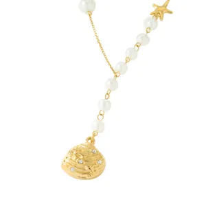 Gros plan détaillé du collier de perles doré style océan avec pendentif coquillage et étoile.