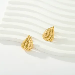 Gros plan de boucles d'oreilles clous larme martelées en acier inoxydable plaqué or 18K.