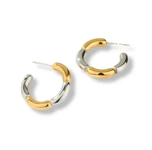 Primer plano de pendientes de aro C segmentados bicolor en metal dorado y plateado brillante.