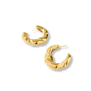 Detailansicht stilvoller goldener verdrehter Creolen, strukturierter Glanz und feines Design.