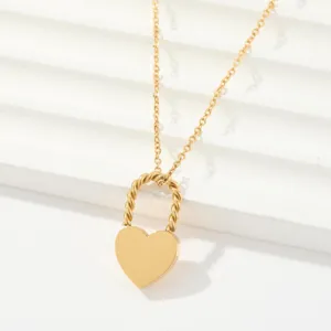 Gold heart lock pendant necklace detail closeup, minimalist style stainless steel chain.