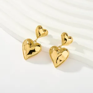 Pendientes colgantes de doble corazón abombado en acero chapado en oro, vista detallada.