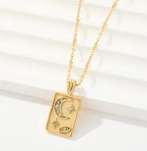Detalle de collar de acero de titanio dorado con colgante de luna y estrella con estrás.