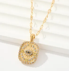 Primer plano detallado del collar con colgante dorado con diseño de sol y cristales.