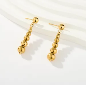 Detalle de los pendientes colgantes de cuentas degradadas chapados en oro fino.