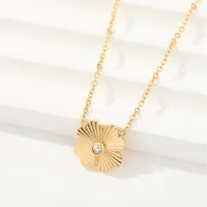 Elegant gold flower pendant necklace with central crystal, minimalist fashion jewelry for daily wear.